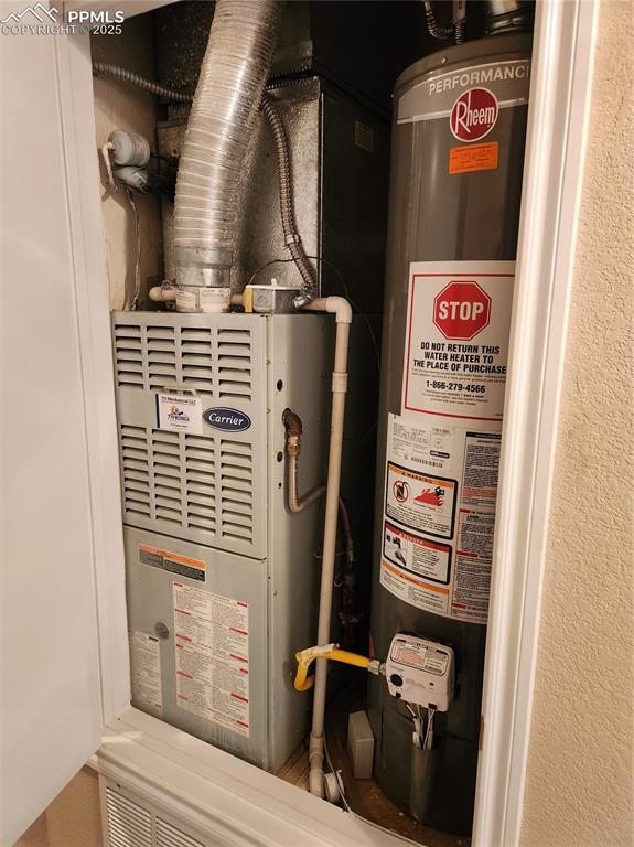 Image 12 of 19: Utility room with gas water heater and heating unit