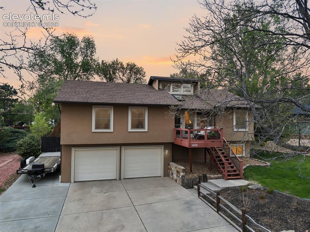 Caption: low maintenance stucco exterior with a 2-car garage and additional parking on the side