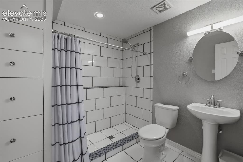 Image 32 of 45: lower level fully updated bathroom with oversized shower