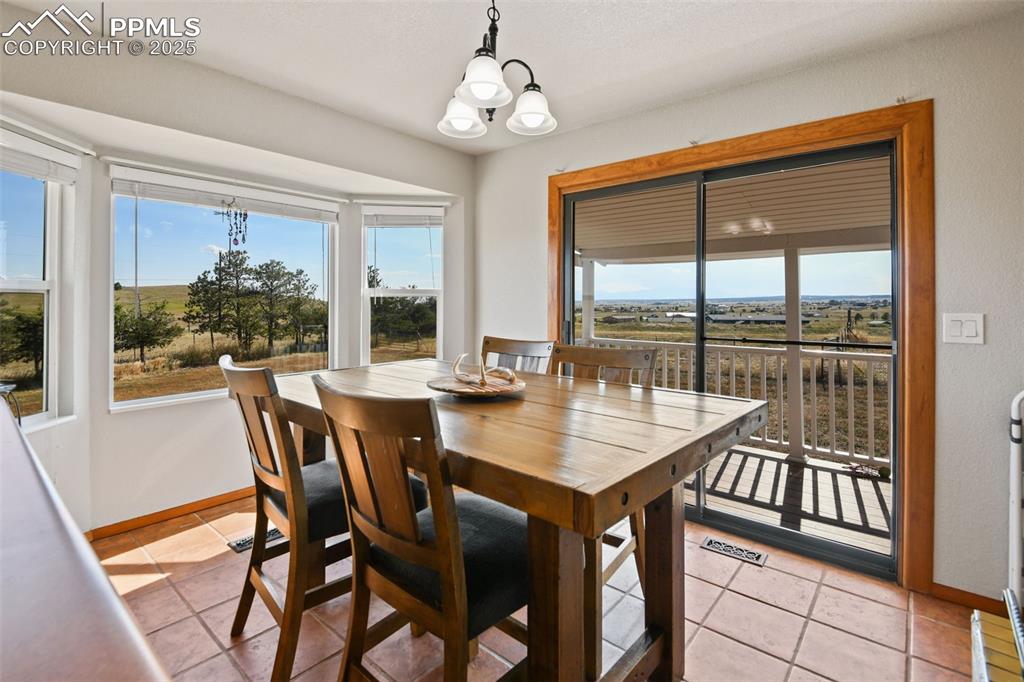 Image 11 of 40: Dining area with a chandelier and light tile patterned flooring
