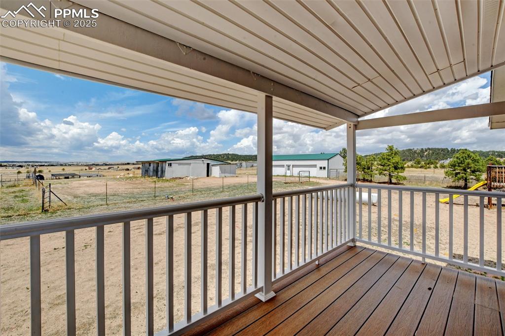 Image 17 of 40: Deck featuring a playground, an outbuilding, and a rural view