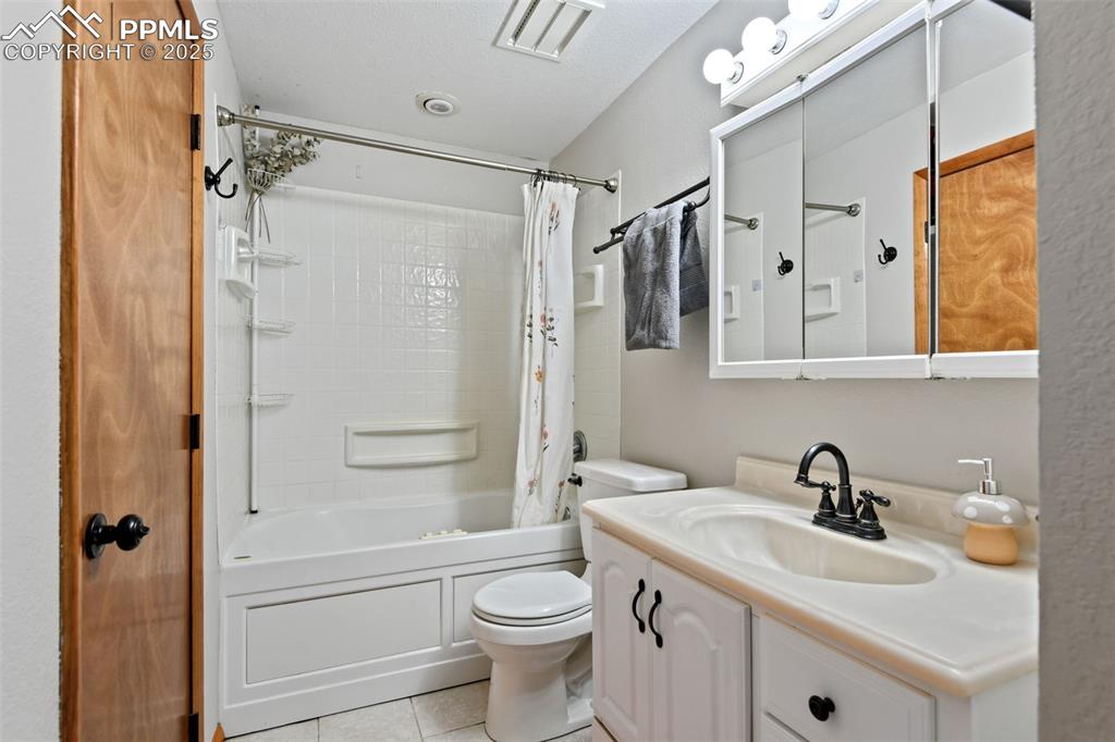 Image 22 of 40: Full bathroom featuring shower / tub combo with curtain, vanity, and light 