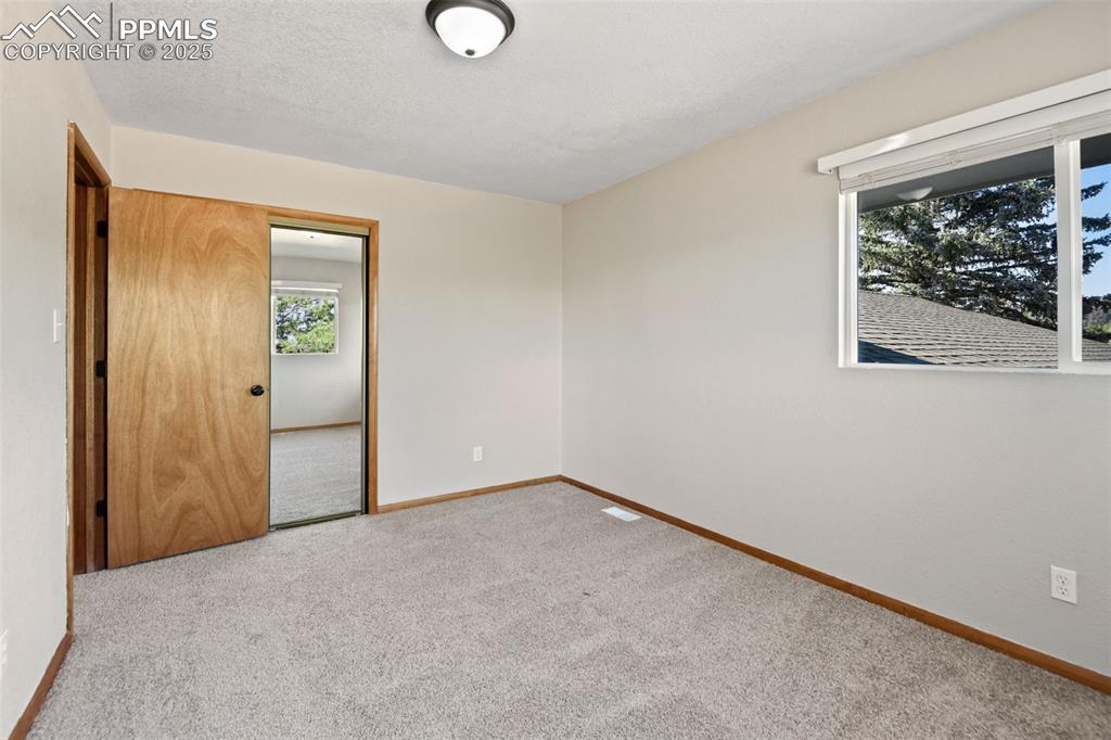 Image 25 of 40: Carpeted spare room with baseboards and a textured ceiling