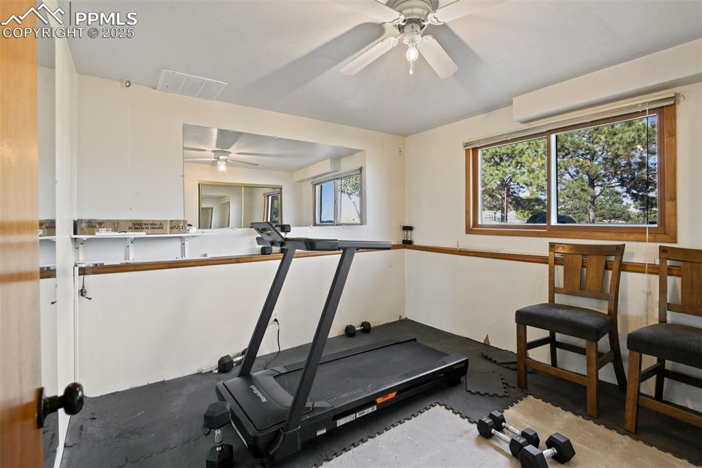 Image 28 of 40: Workout room featuring plenty of natural light and a ceiling fan