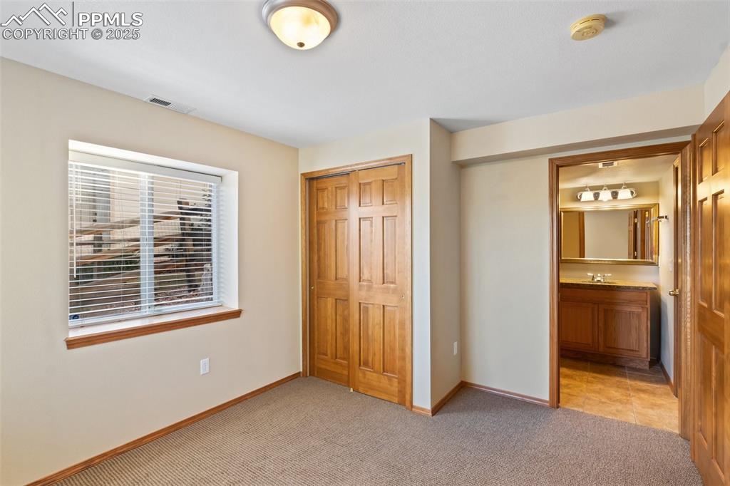 Image 30 of 44: Bedroom 5 in basement is attached to a 3/4 bath.