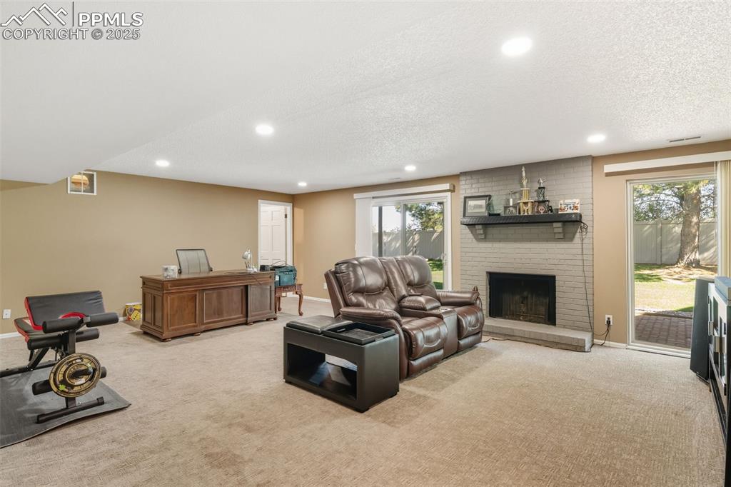 Image 18 of 35: Family room with fireplace and walkout to lower level patio