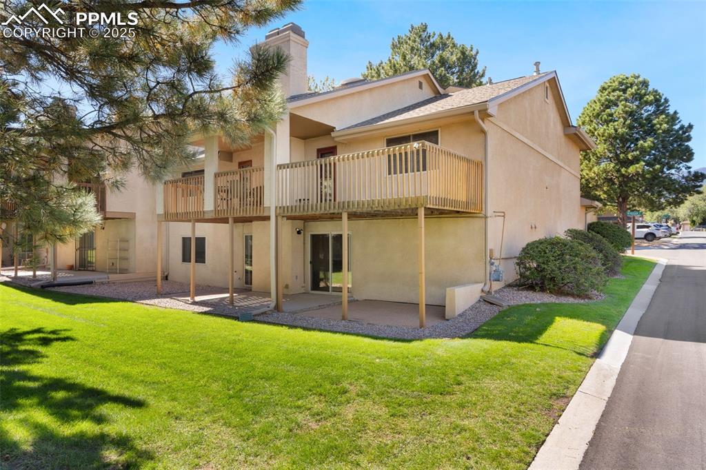 Image 20 of 35: Patio connects to green space behind condo