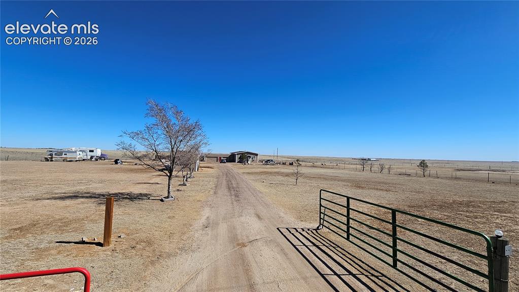 Image 1 of 48: Expansive rural property featuring a long gravel driveway, a distant reside