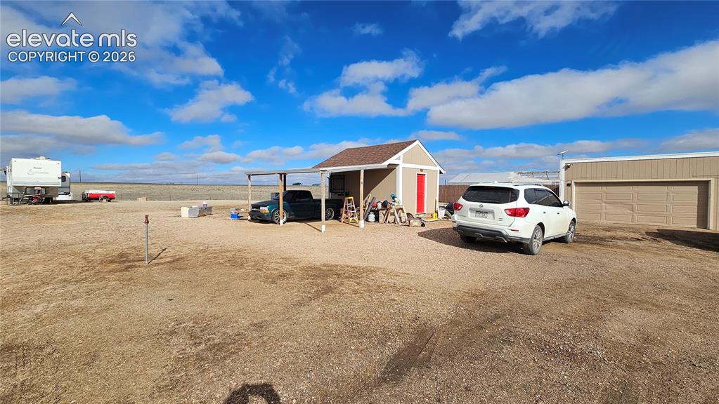 Image 11 of 48: Spacious property featuring a detached garage, a separate shed with a red d