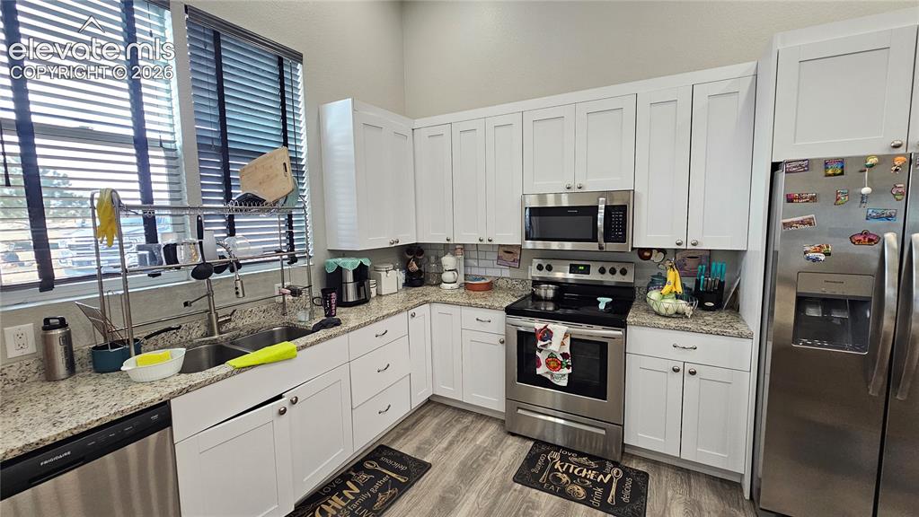 Image 13 of 48: Modern kitchen featuring white shaker cabinetry, stainless steel appliances