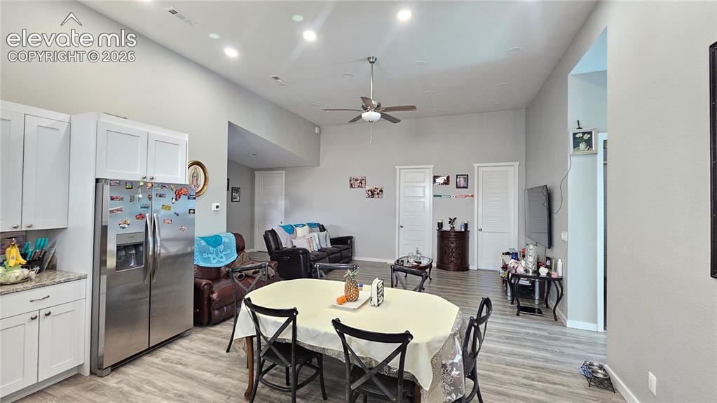 Image 16 of 48: Open-concept living area featuring high ceilings, recessed lighting, and wo