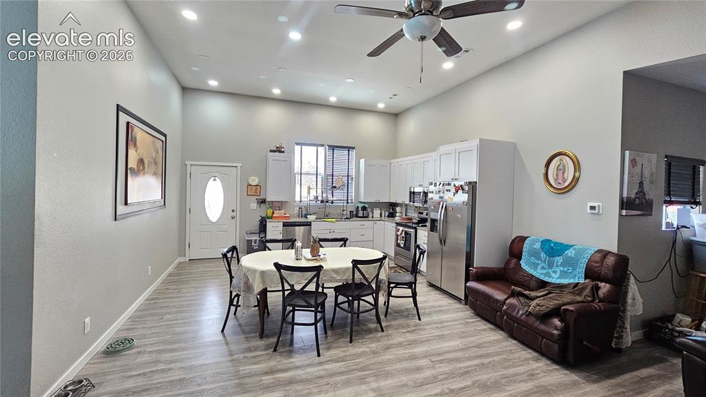Image 18 of 48: Open-concept living area featuring wood-finish flooring and a vaulted ceili