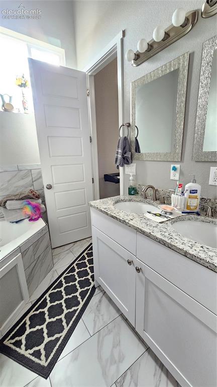 Image 25 of 48: Double vanity with undermount sinks and granite countertops, set against a