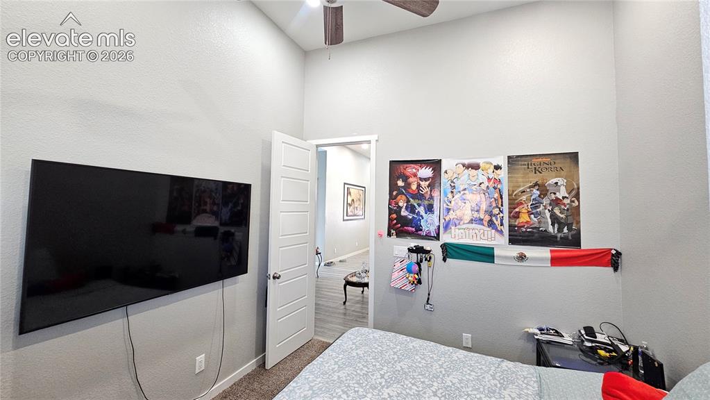 Image 29 of 48: Carpeted interior space with light gray walls and a high vaulted ceiling