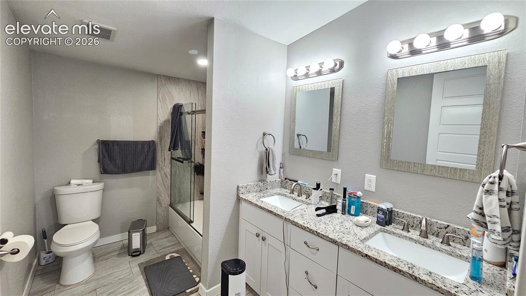 Image 30 of 48: Dual vanity with granite countertops, undermount sinks, and brushed nickel