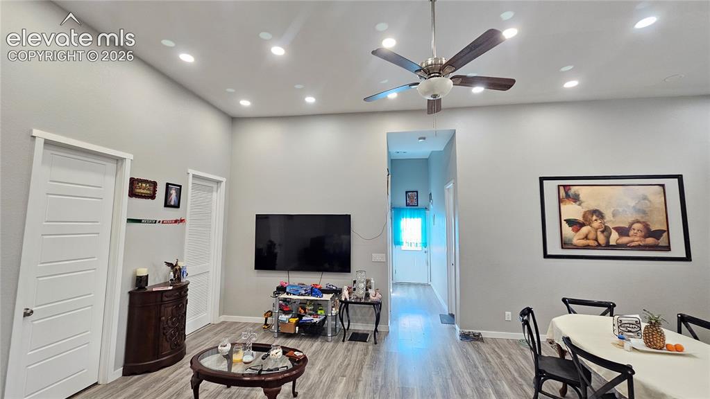 Image 32 of 48: Spacious open-concept interior featuring light gray walls, wood-finish floo