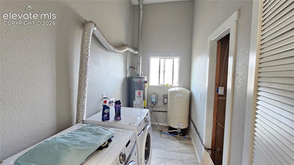 Image 34 of 48: Dedicated utility room with a compact window, tile flooring, and louvered b
