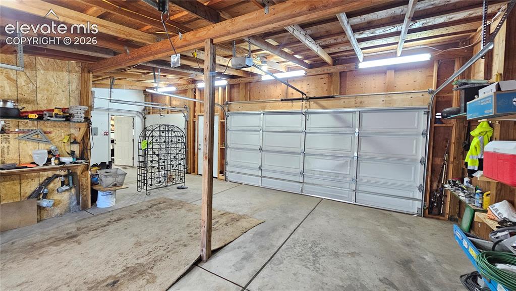 Image 39 of 48: Multi-car garage featuring exposed wood beam ceiling, concrete flooring, an