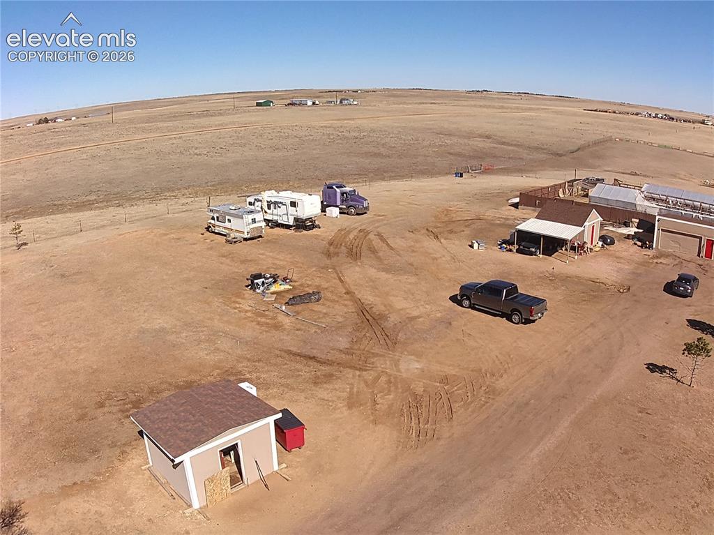 Image 41 of 48: Expansive open land featuring multiple structures, including a small buildi
