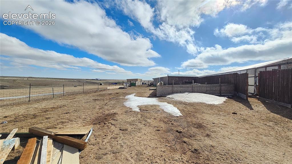 Image 6 of 48: Expansive fenced property featuring multiple outbuildings with metal roofin