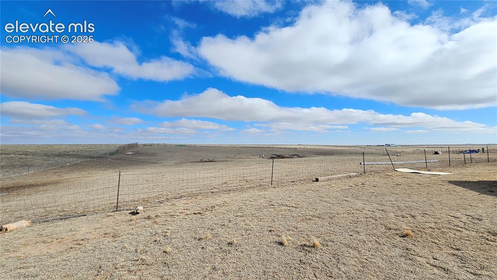 Image 7 of 48: Expansive open terrain featuring natural vegetation, a wire fence line, and