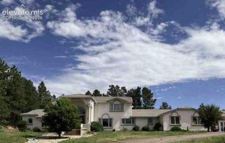 Caption: View of front of property featuring stucco siding