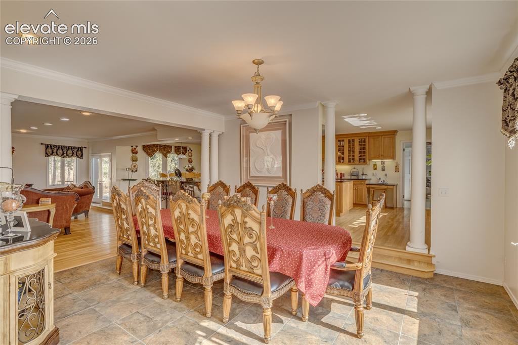 Image 11 of 32: Dining room featuring decorative columns, crown molding, a chandelier, and 