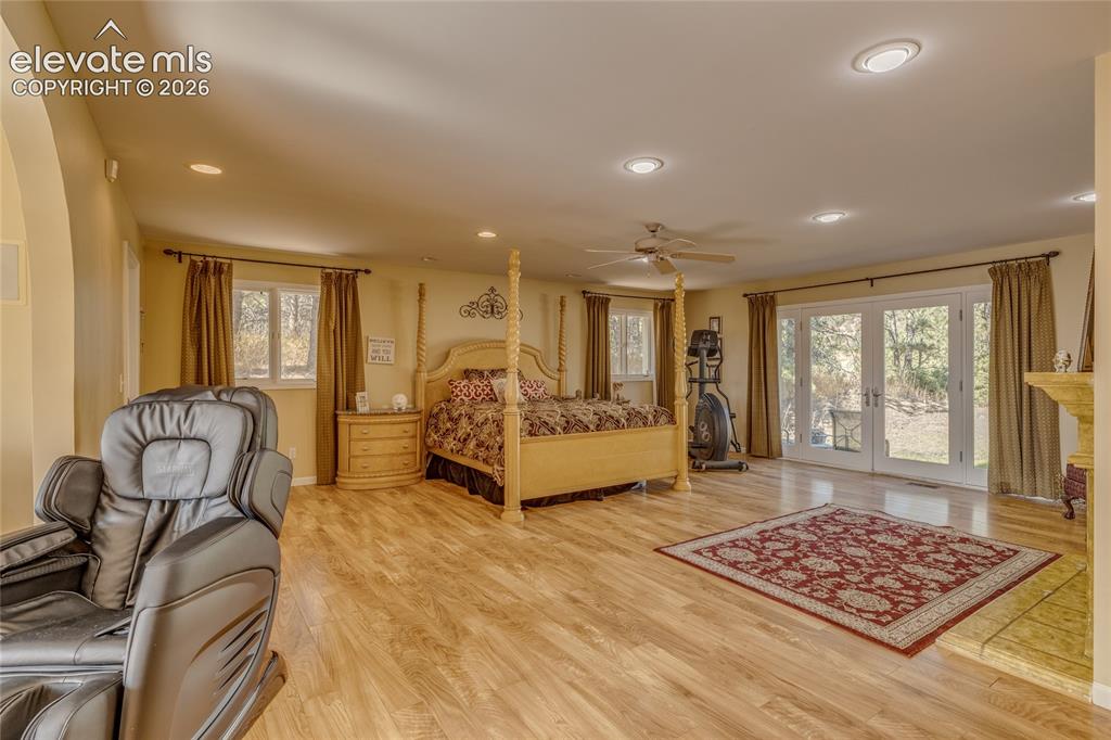 Image 12 of 32: Bedroom featuring access to exterior, light wood finished floors, recessed 