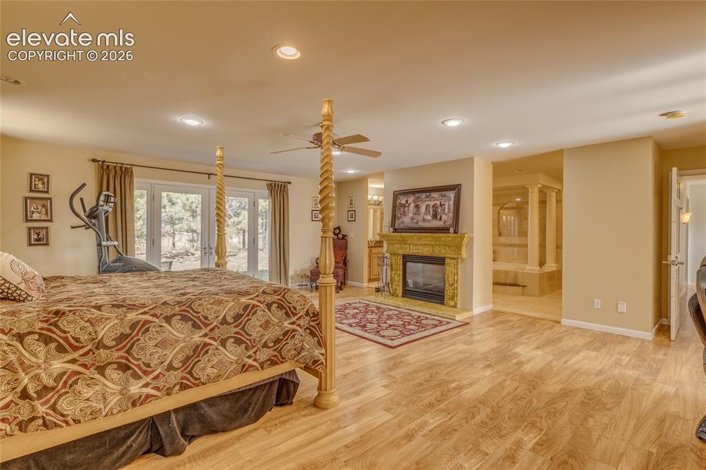 Image 14 of 32: Bedroom featuring recessed lighting, a glass covered fireplace, access to o