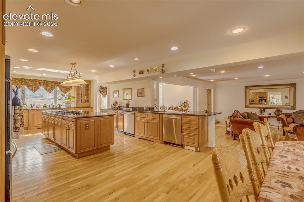 Image 17 of 32: Kitchen with open floor plan, a kitchen island, light wood finished floors,