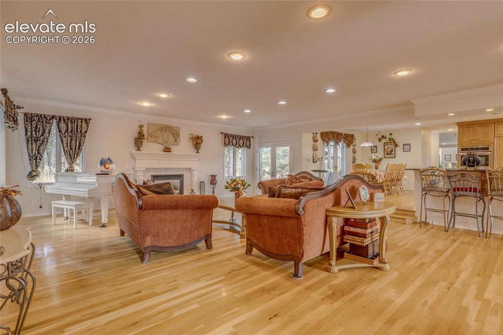 Image 9 of 32: Living room with crown molding, recessed lighting, light wood finished floo