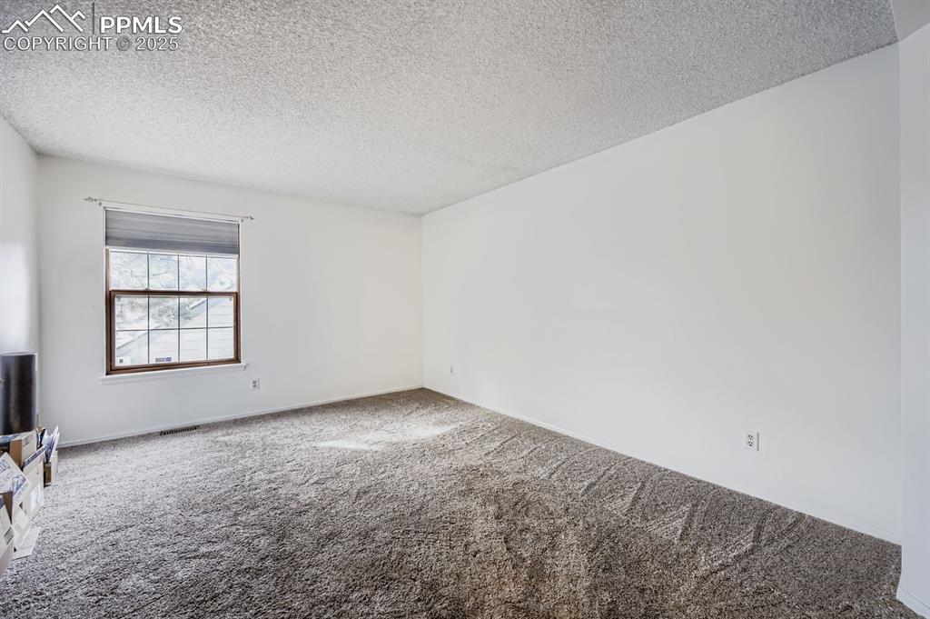 Image 13 of 25: Carpeted spare room featuring a textured ceiling