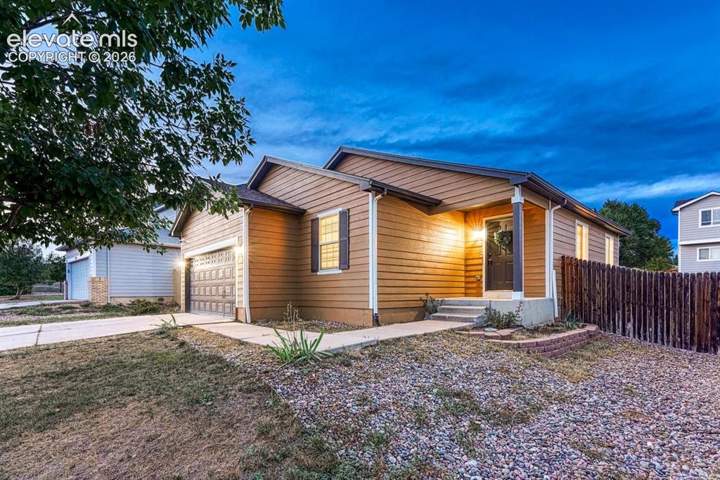 Image 11 of 35: Low maintenance landscaping and covered front porch.