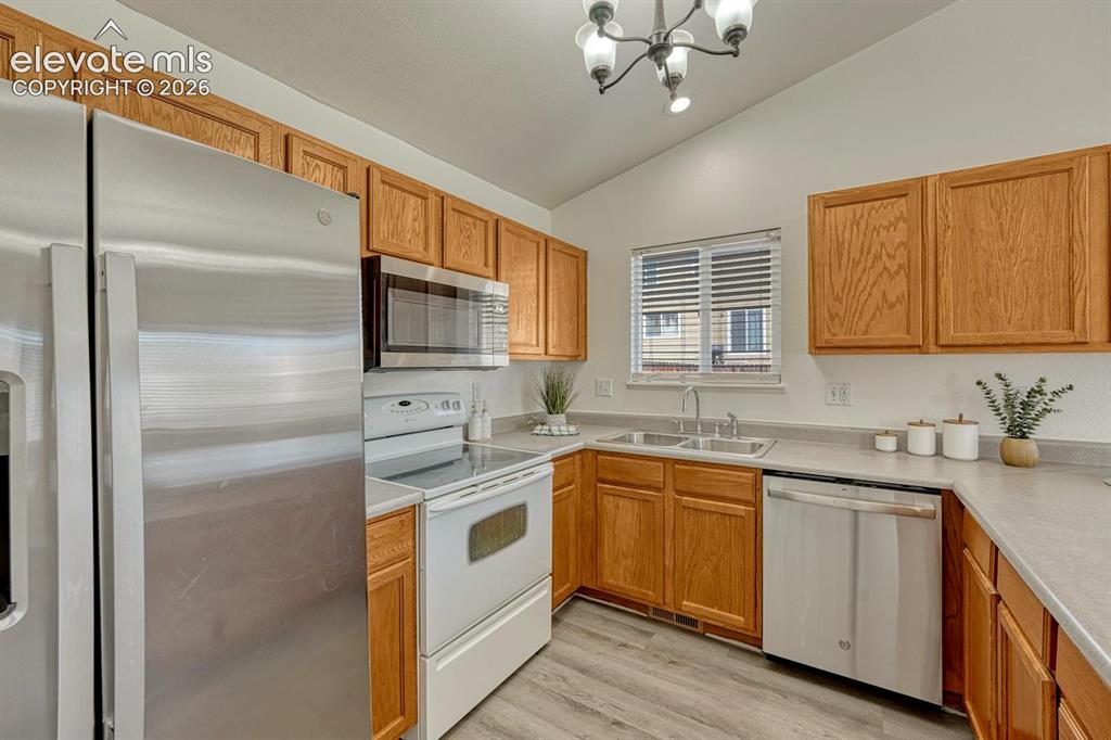 Image 15 of 35: Kitchen appliances include a stainless steel side by side refrigerator, smo
