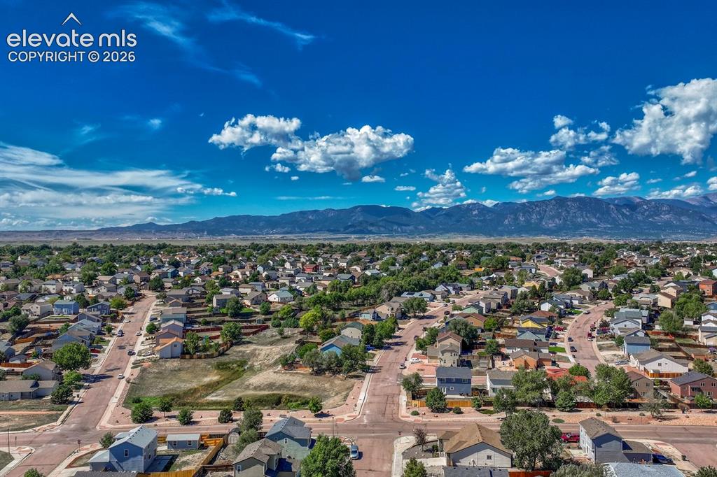 Image 32 of 35: Aerial view of neighborhood and surrounding mountains.