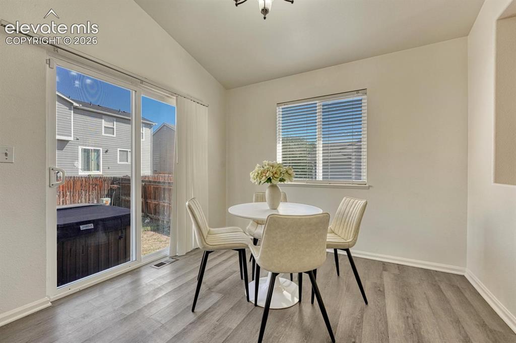 Image 5 of 35: Walk Out Dining Area with wood laminate flooring.
