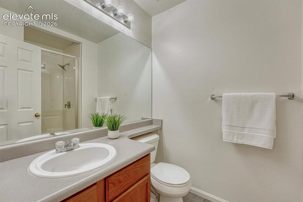 Image 8 of 35: Primary Shower Bathroom with vanity, mirror, and tiled shower.