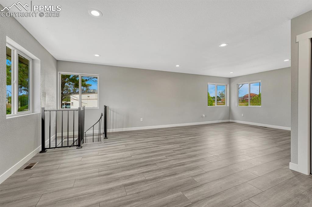Image 10 of 50: Empty room with recessed lighting and light wood-style floors