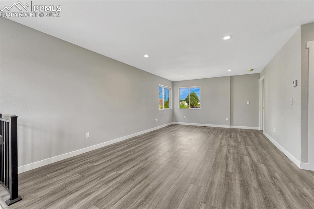 Image 11 of 50: Empty room with light wood-type flooring and recessed lighting