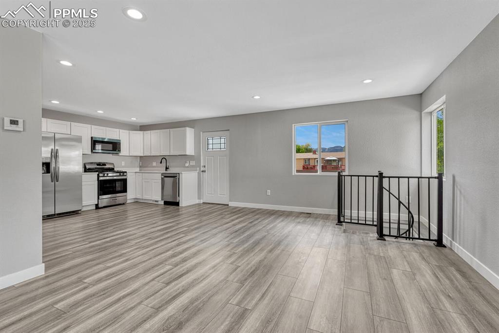 Image 13 of 50: Unfurnished living room with recessed lighting and light wood-style floorin