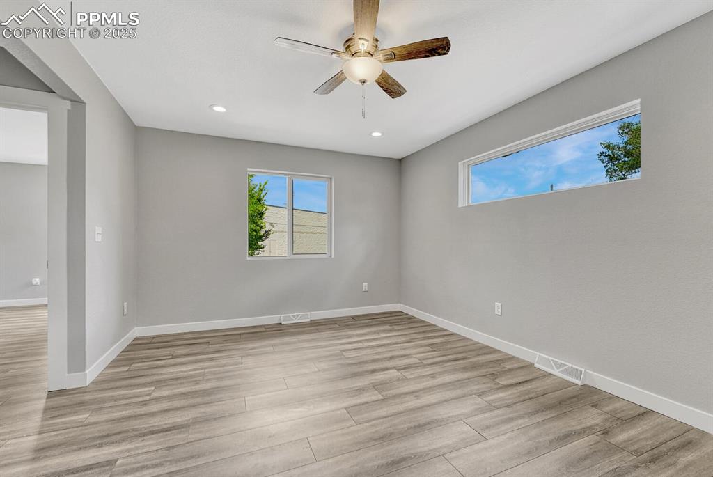 Image 19 of 50: Empty room featuring healthy amount of natural light, light wood finished f