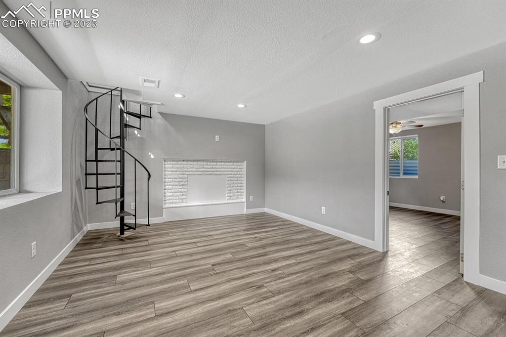 Image 30 of 50: Unfurnished living room with light wood-style floors, recessed lighting, st