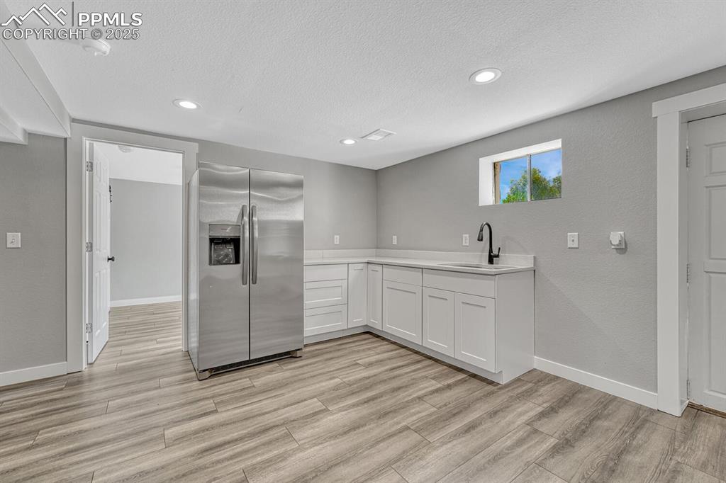 Image 34 of 50: Kitchen with stainless steel fridge with ice dispenser, a textured ceiling,