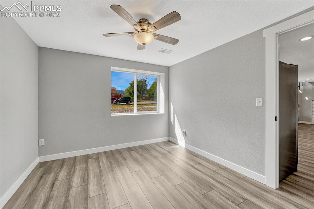 Image 38 of 50: Unfurnished room with light wood finished floors, a textured wall, a textur