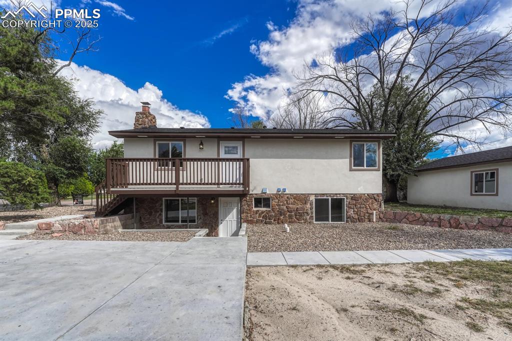 Image 4 of 50: View of front of house with stone siding, stucco siding, stairs, and a chim
