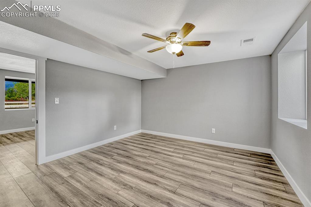 Image 45 of 50: Spare room with light wood-style flooring, a ceiling fan, and a textured ce