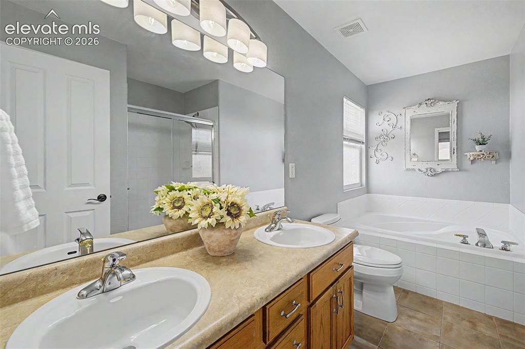 Image 17 of 43: Primary Ensuite Bathroom with Dual Vanities & Soaking Tub