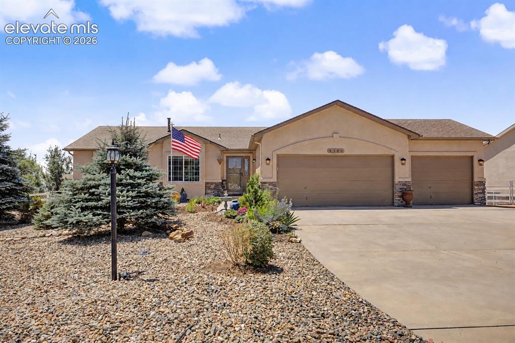 Image 2 of 43: Xeriscaped Front Yard with Beautiful Landscaping and Three Car Garage