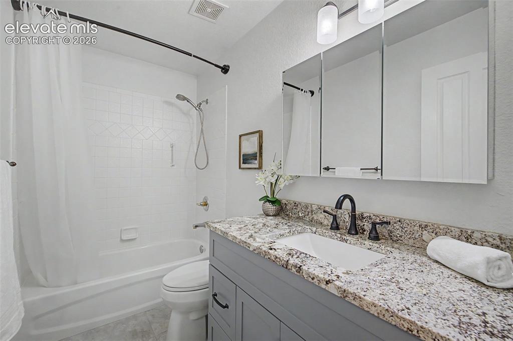 Image 21 of 43: Main Level Full Bathroom with Updated Cabinets & Granite Countertops 