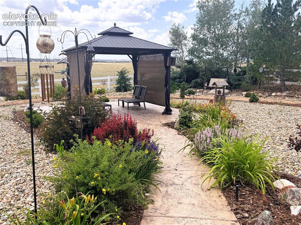 Image 34 of 43: Beautiful Stamped Walk way, Gorgeous Flowerbeds and Gazebo in Backyard